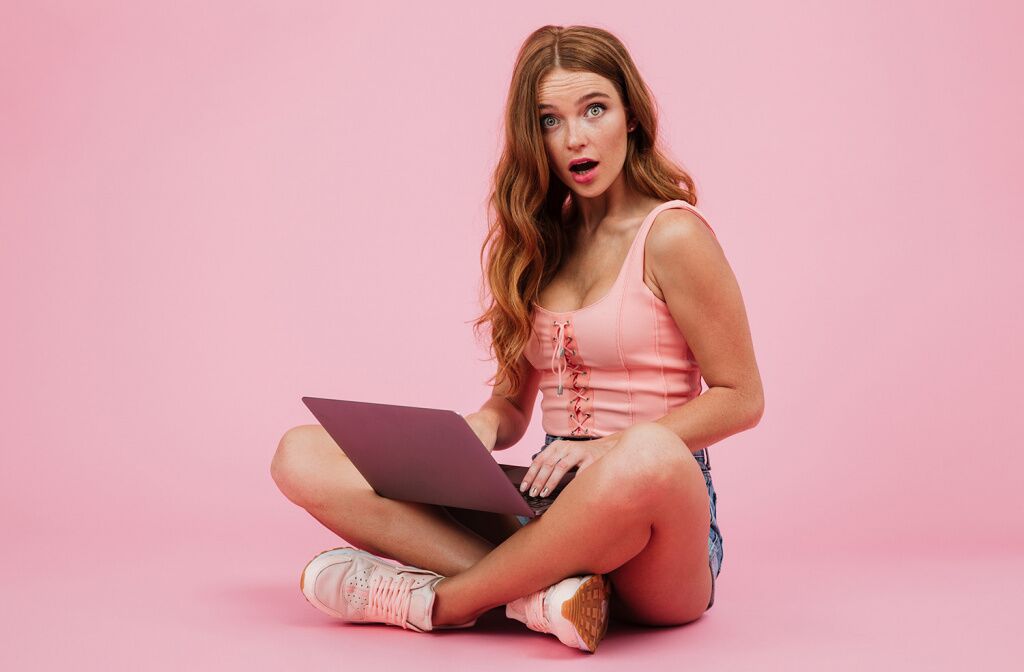 photo-young-amazed-readhead-woman-with-laptop-siiting-with-crossed-legs.jpg